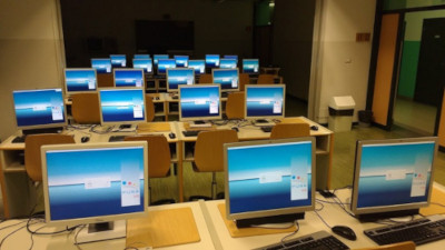 Photo of a FUSS computer lab showing around twenty PC screens.